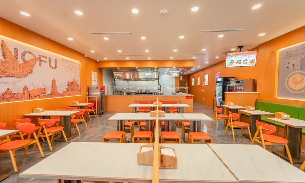Spacious dining area with orange chairs, tables, and decorative walls at YGF Malatang-Katy, a Chinese Restaurant in Katy