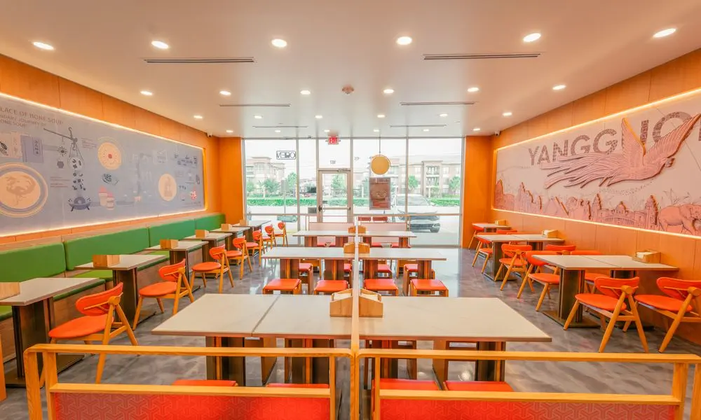 Spacious dining area with green booths, orange seating, and decorative walls at YGF Malatang-Katy, a Chinese Restaurant in Katy