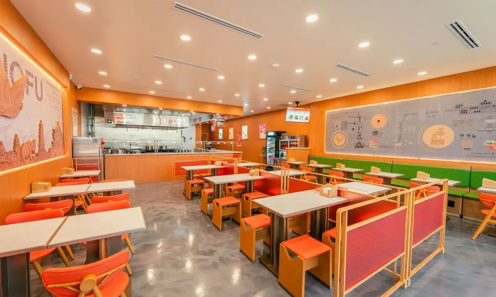 Dining space with partitioned seating, orange furniture, and a bright ambiance at YGF Malatang-Katy, a Chinese Restaurant in Katy